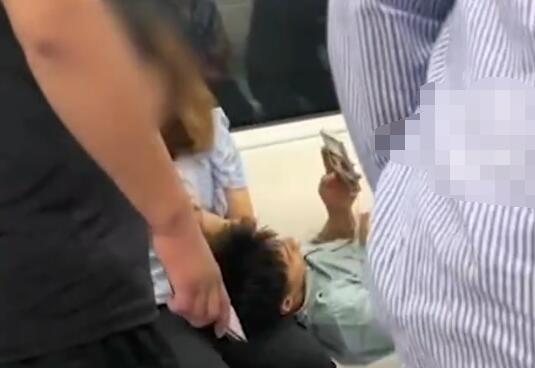 男子地铁占座躺女友腿上玩手机 周围乘客提醒男子也未起身