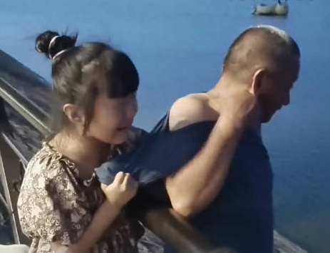 爷爷想下河捞玩具被孙女紧紧拉住 孙女担心地大哭紧拽爷爷衣服阻止